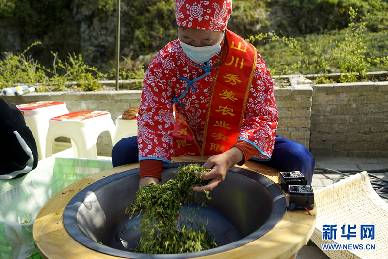 一位技师向游客演艺炒茶方法