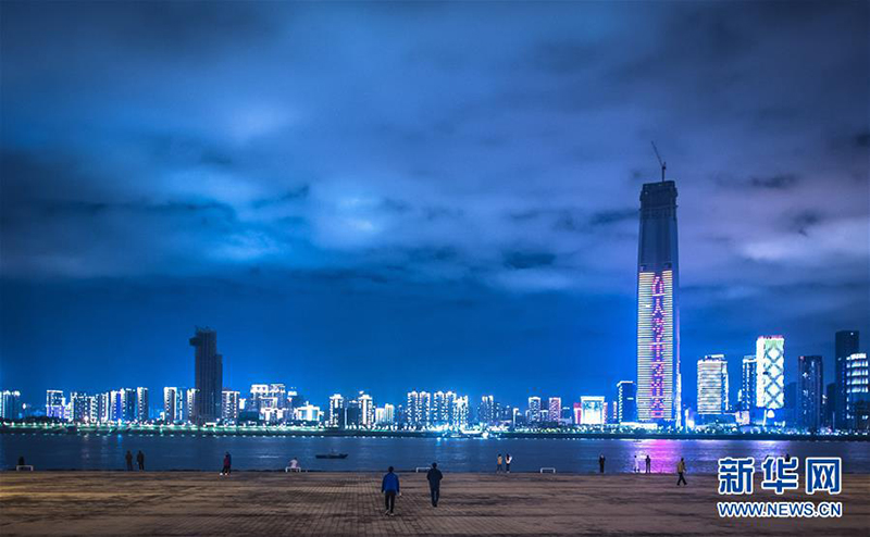 3月26日晚，市民在汉口江滩公园三阳广场江边拍照