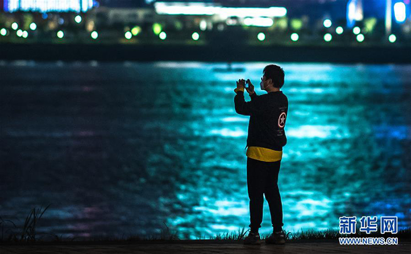 3月26日晚，市民在汉口江滩公园江边拍照