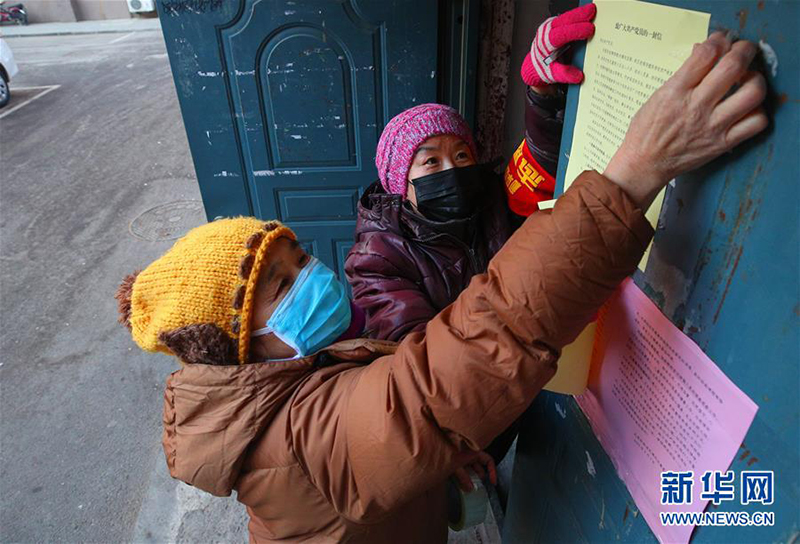 　辽宁省沈阳市和平区太原街街道民族社区的志愿者在张贴防疫宣传单