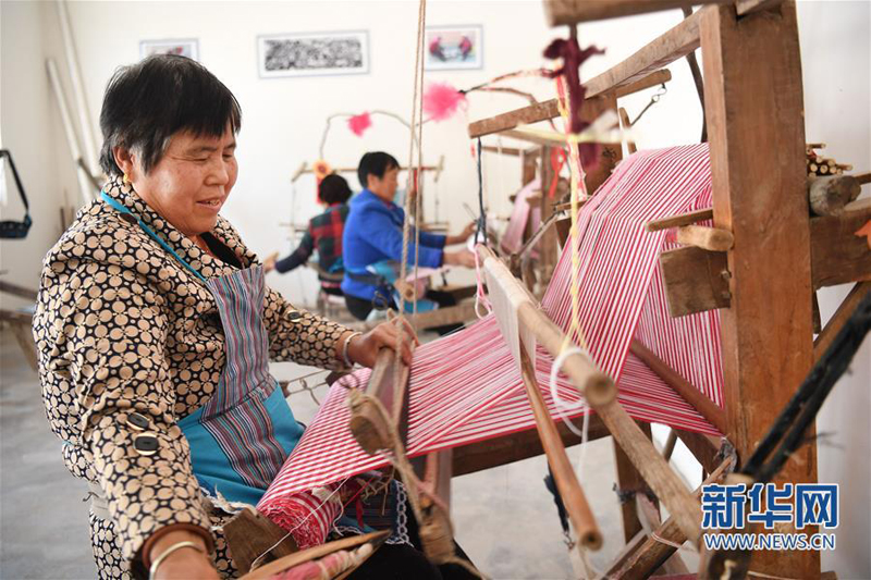 4月25日，合阳县黑池镇西中雷社区贫困户王玲娃在老式织布机上织布。