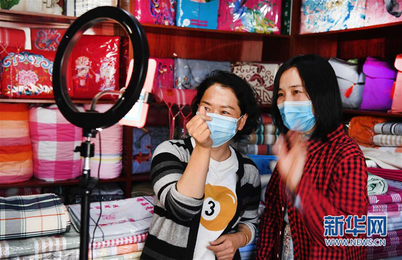 4月25日，马艳勤（左）在实体店直播推介合作社生产的粗布产品。