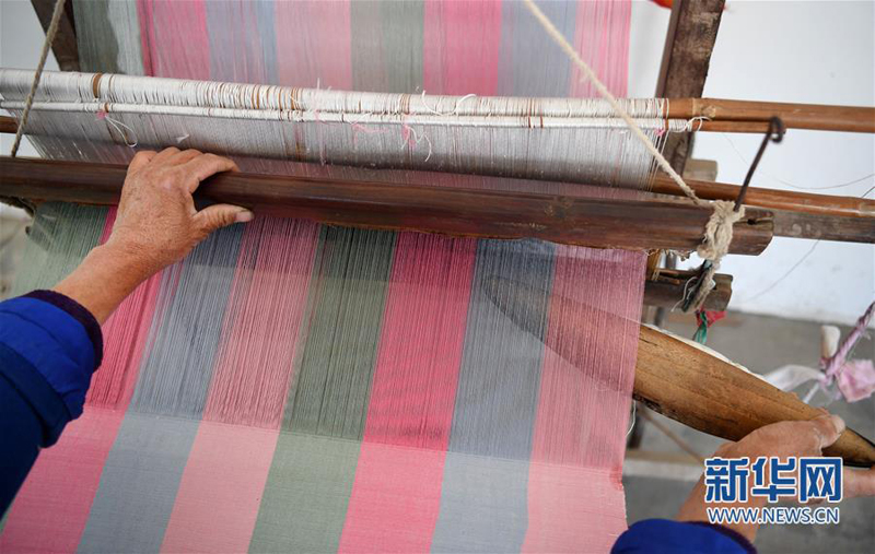 4月25日，合阳县黑池镇西中雷社区的乡亲坐在老式织布机前织布。