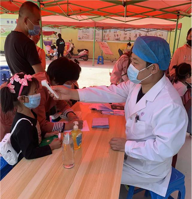 魏升升医师为前来接种的儿童和家属测量体温