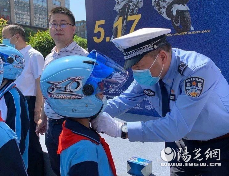 西安交警莲湖大队向二府街小学的小学生们赠送安全头盔。