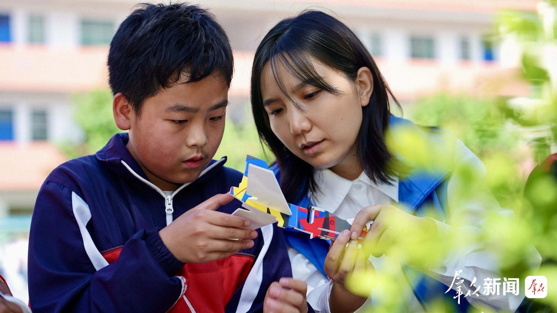 5月26日,商洛学院副教授、流动科技馆指导教师杨琳(右)在洛南县古城镇小学手把手指导学生组装航模飞机。杨琳带领师生打造的“流动科技馆”志愿服务项目,研发科技展品200余件,以情景剧、云端课堂等创新形式,深入160多所乡村学校、服务超10万人次,有效破解山区科普资源匮乏难题,成为服务秦岭青少年的国家级特色科普标杆。群众新闻记者 蒲茜摄 75ffd00c26e9899f4445d1e2d34574f7.jpeg